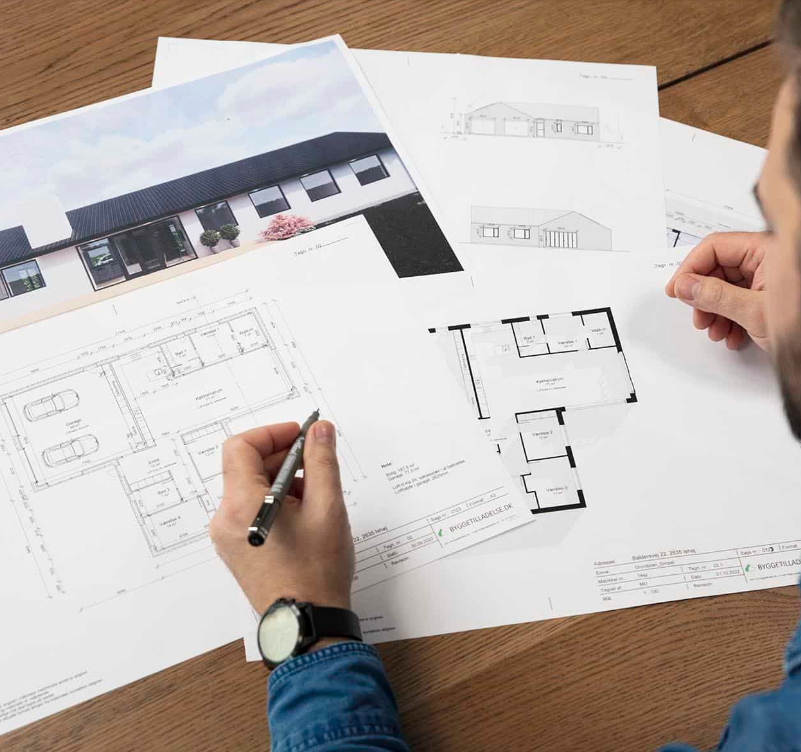 Arkitekt arbejder med tegninger og plantegninger